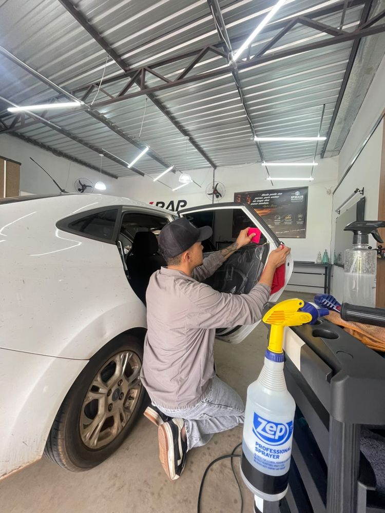 Aplicador instalando insulfilm no vidro de um carro