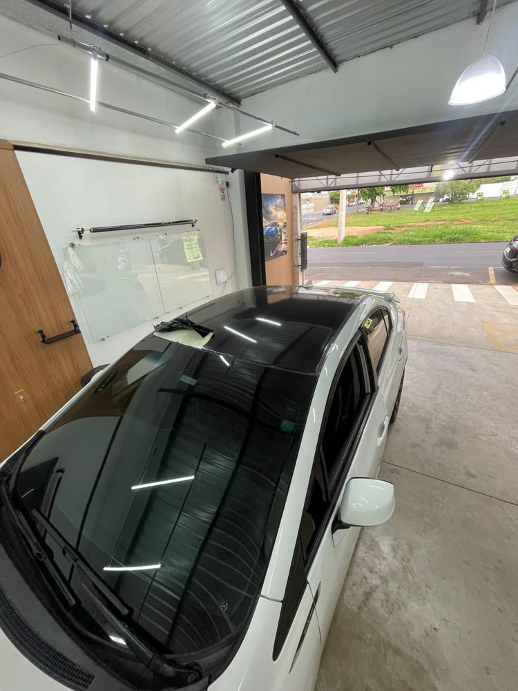 Carro branco com teto envelopado em preto